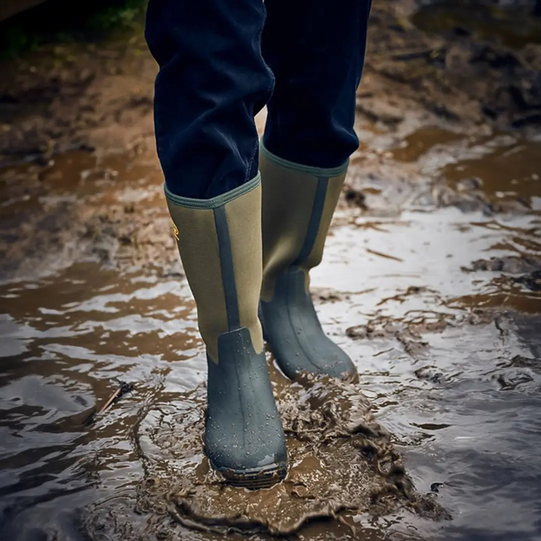 Green Grubs Frostline Classic 5.0 Wellington boots in muddy water for country clothing and outdoors