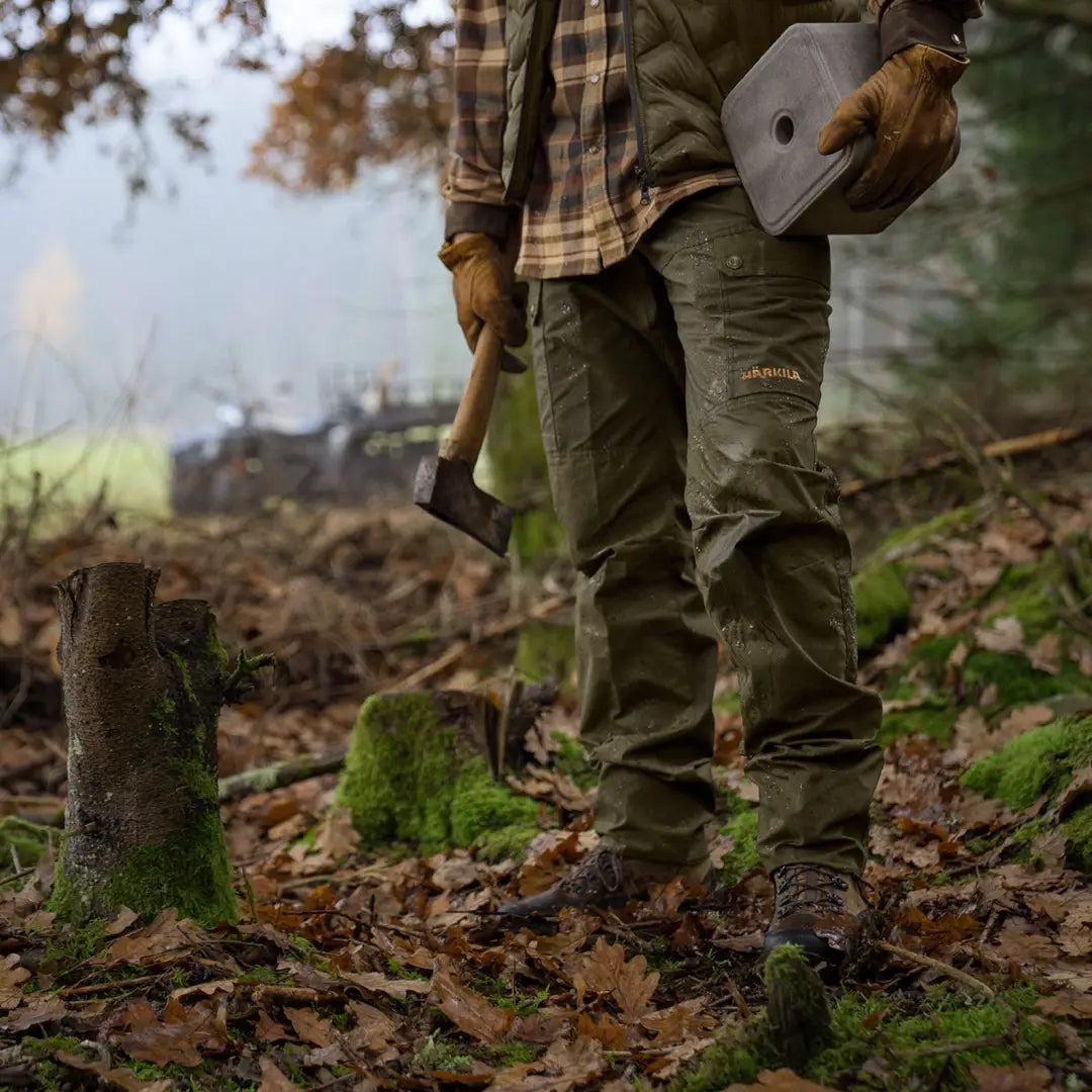 Person in the forest wearing Harkila Asmund Trousers made of lightweight waxed canvas