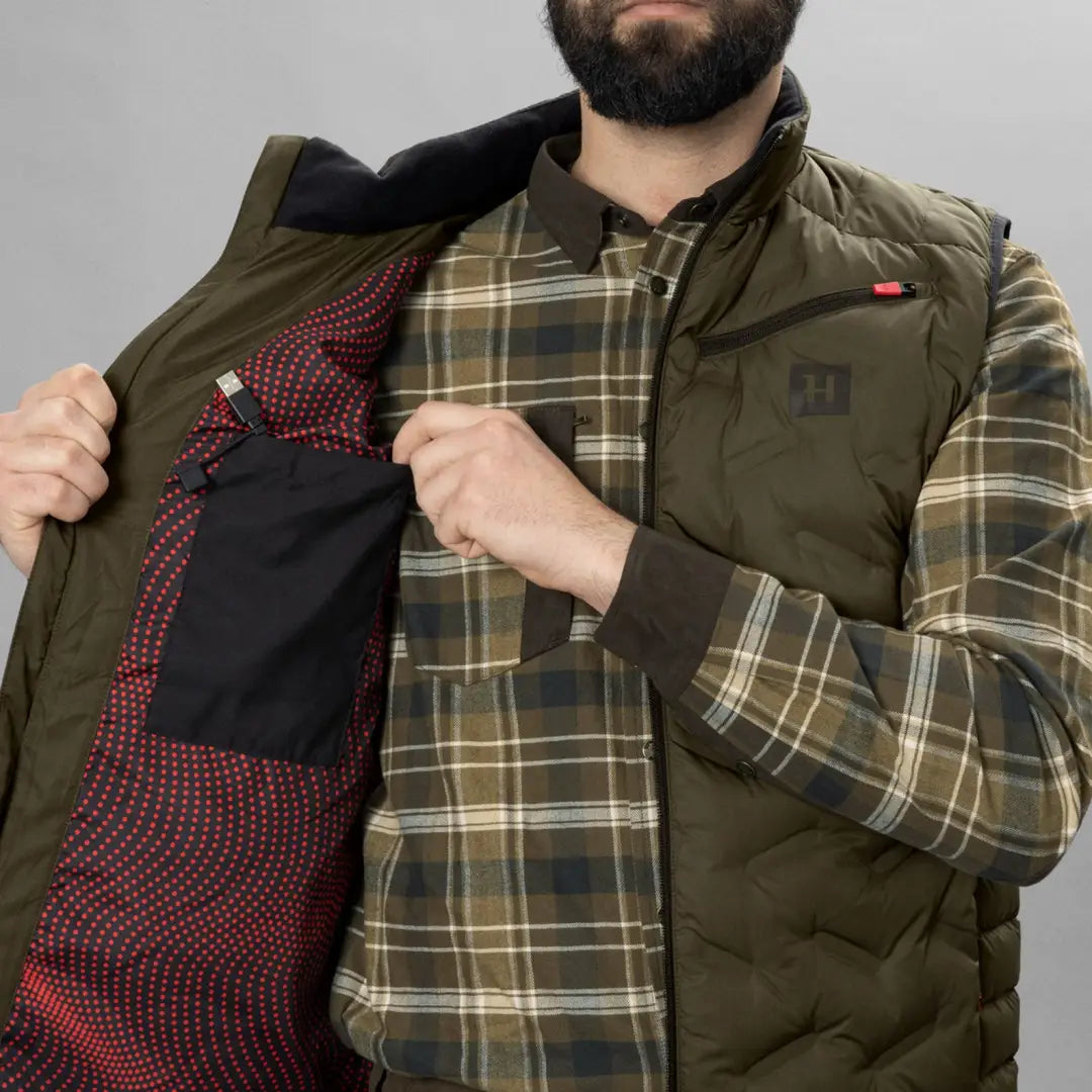 Olive green puffy vest over plaid flannel, perfect for your Harkila Clim8 Insulated Waistcoat