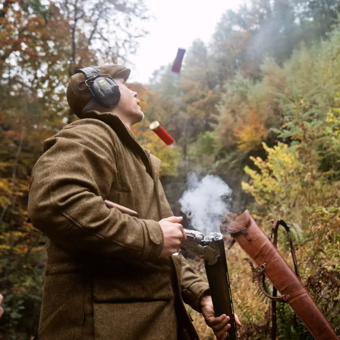 Hunter reloading shotgun in autumn forest showcasing Kenmore GTX Jacket’s classic style