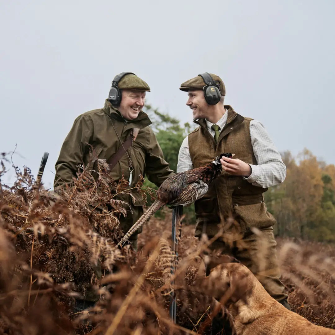 Two hunters in traditional attire showing off a pheasant with Härkila Kenmore Waistcoat