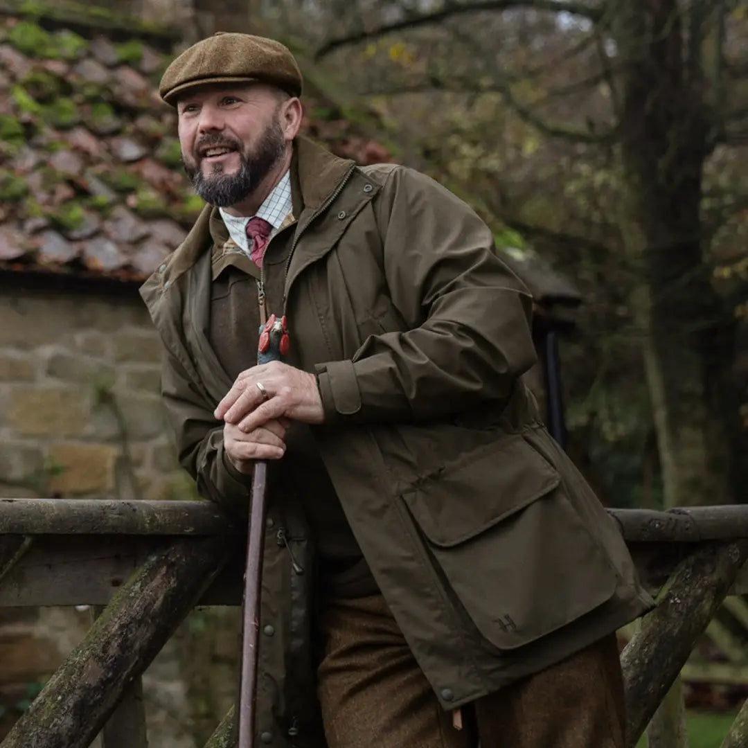 Man in classic hunting jacket, Harkila Orton Tech HWS, leaning on wooden fence