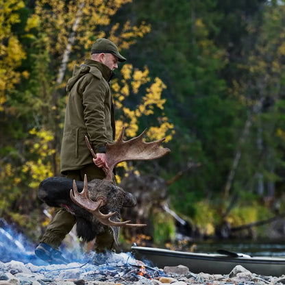 Hunter carrying moose antlers in water wearing Harkila Pro Hunter Endure Jacket