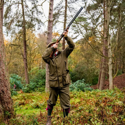 Hunter aiming a shotgun in the forest wearing the Harkila Pro Hunter Endure Jacket