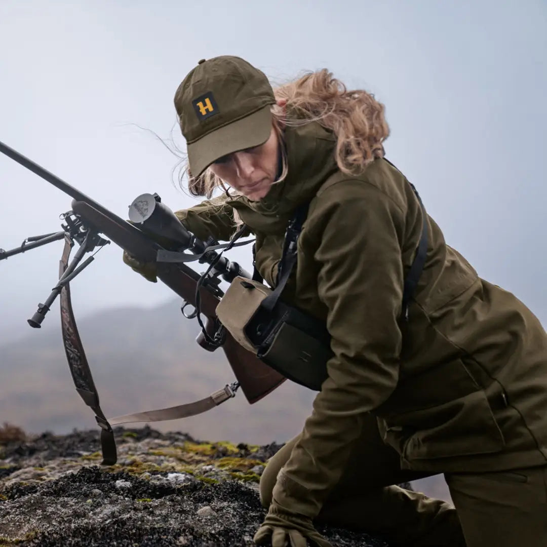 Soldier in military gear aiming sniper rifle, showcasing Harkila Pro Hunter GTX Ladies Jacket