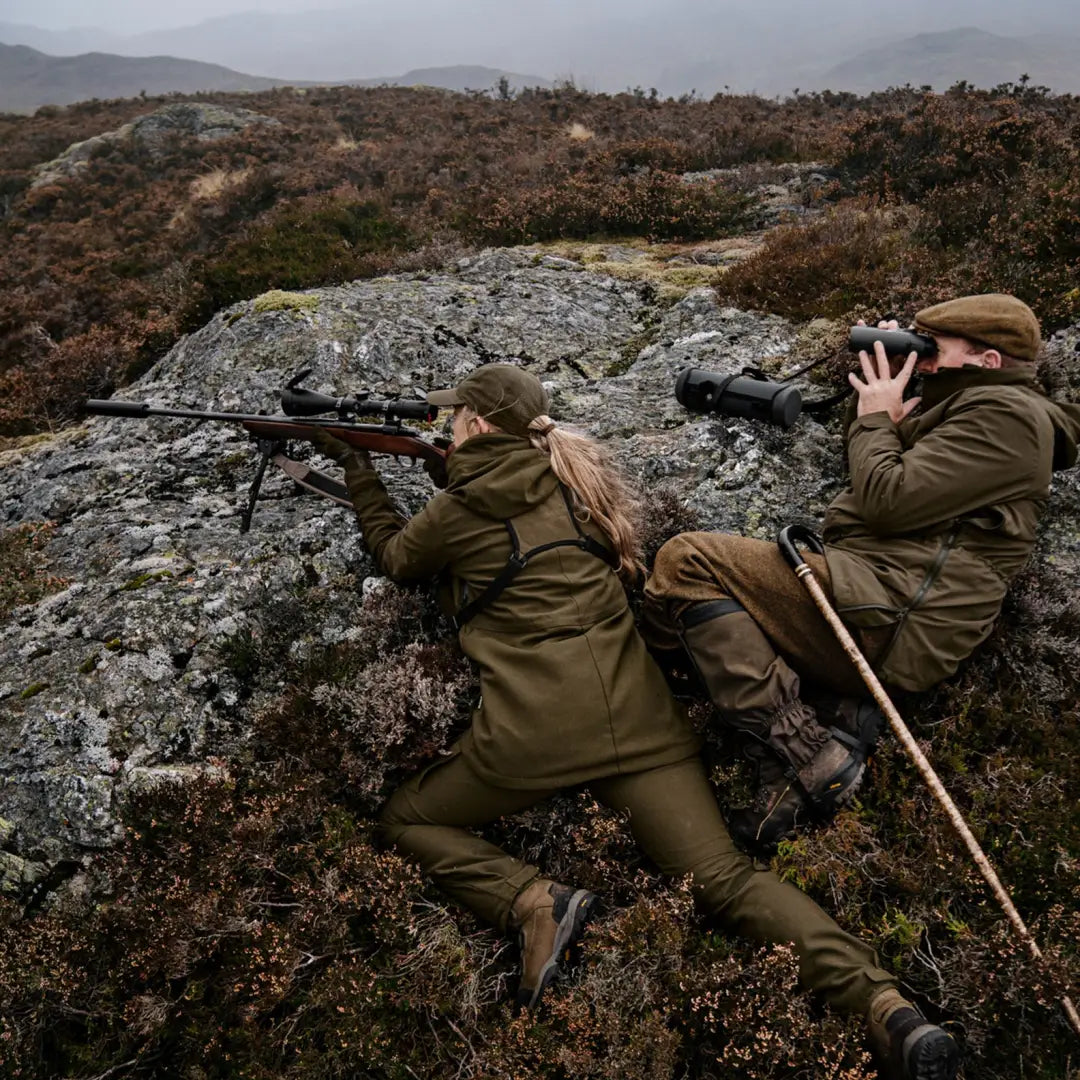 Two people in military gear on rocky terrain, testing the Harkila Pro Hunter GTX Ladies Jacket