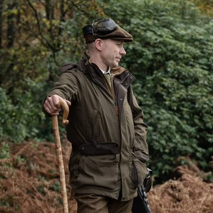 Man in traditional countryside attire with walking stick, showcasing Pro Hunter Shooting Jacket