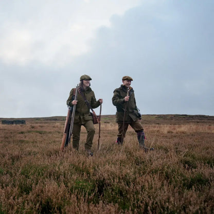 Two hunters in a field with rifles wearing Harkila Pro Hunter Shooting GTX Jacket