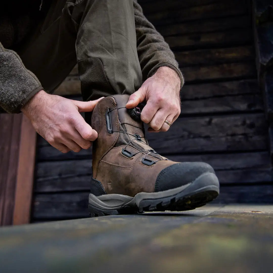 Rugged Harkila Reidmar Mid 2.0 GTX Boots being laced up for outdoor adventures