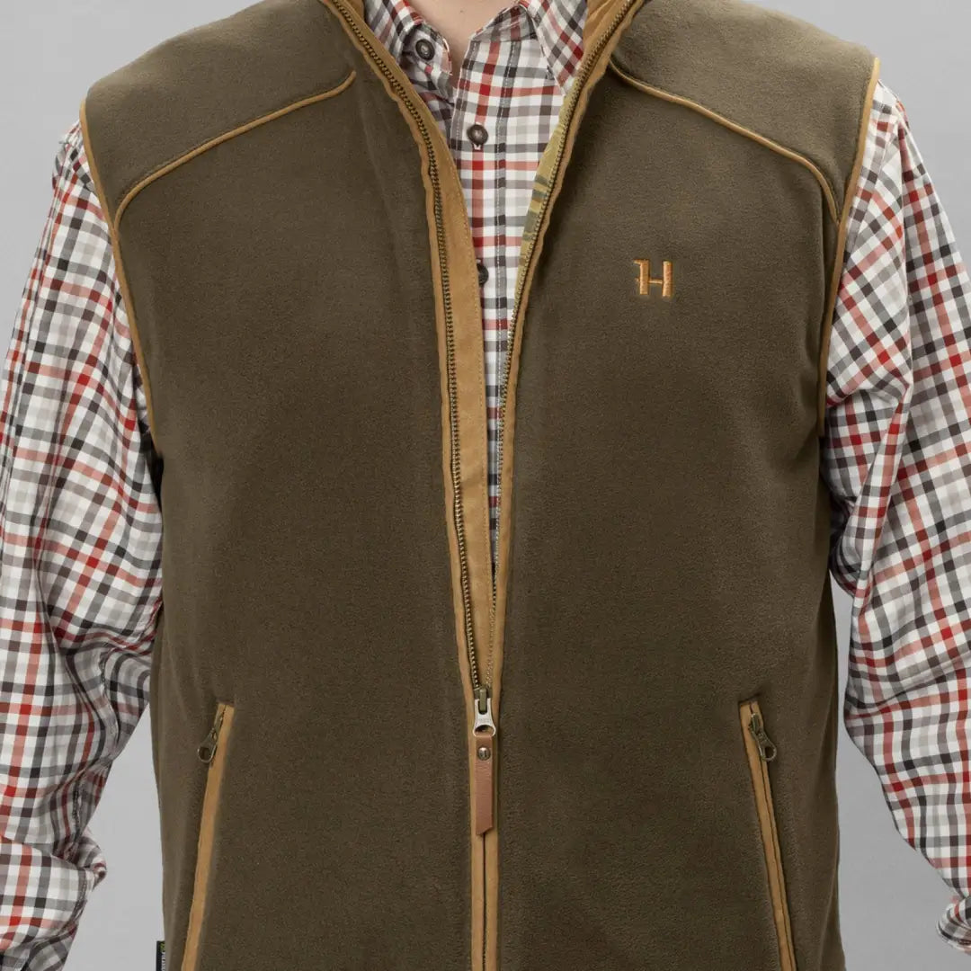 Olive green Harkila Sandhem vest over plaid shirt, perfect for country clothing and hunting