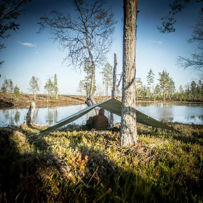 Tent set up with Helikon-Tex Supertarp Small by a calm lake, ideal for harsh weather