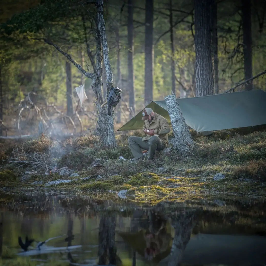 Tent pitched in misty forest by calm pond, showcasing Helikon-Tex Supertarp Small for harsh weather