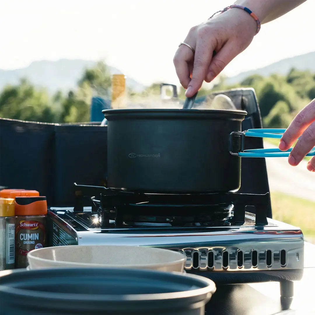 Portable camping stove with pot in use from the Highlander Apex Weekender Camping Cookset