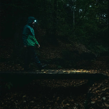 Person exploring dark woods with Highlander Hadar Rechargeable Head Torch