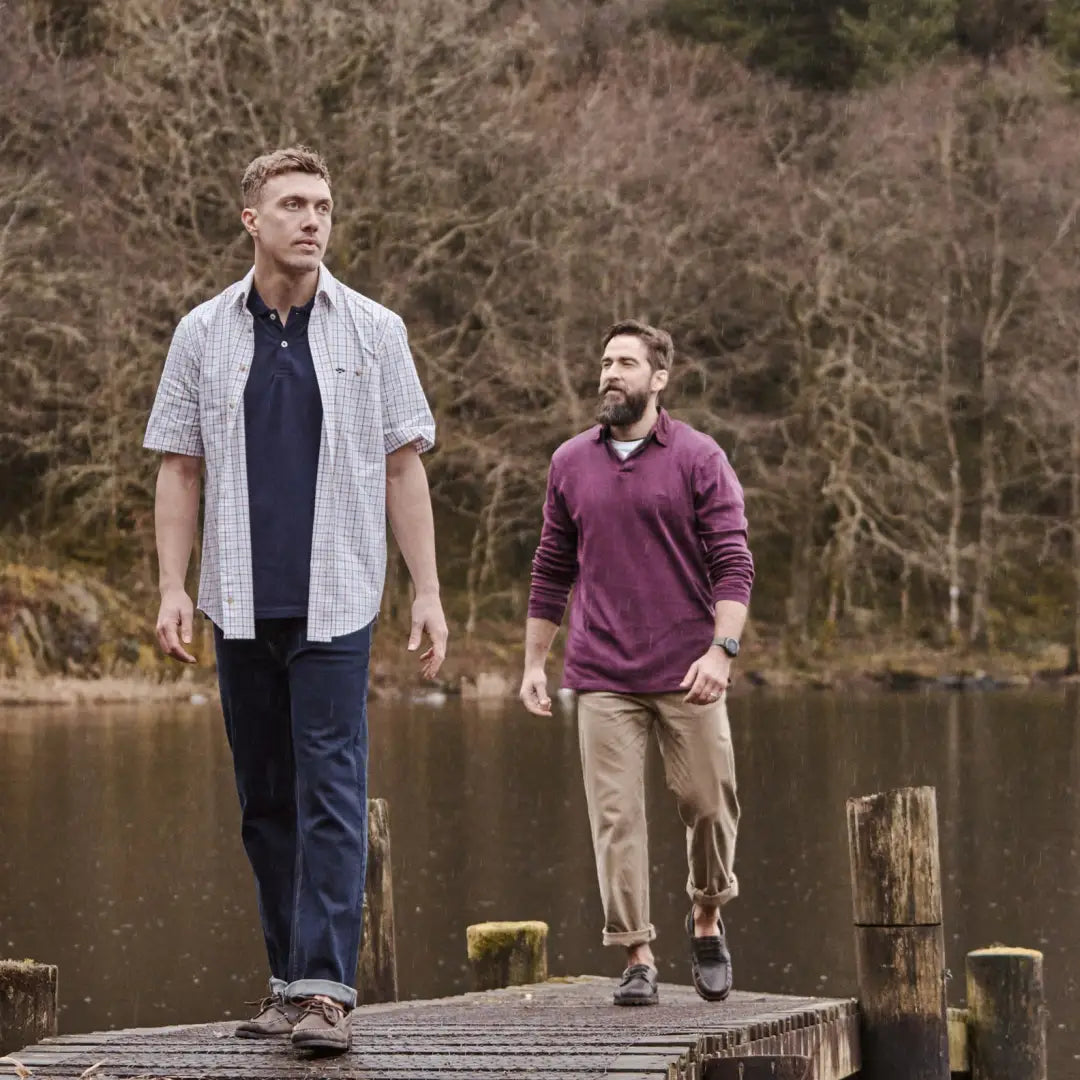 Two men in Fife Kessock Tattersall Short Sleeve Shirts stroll along a lake dock