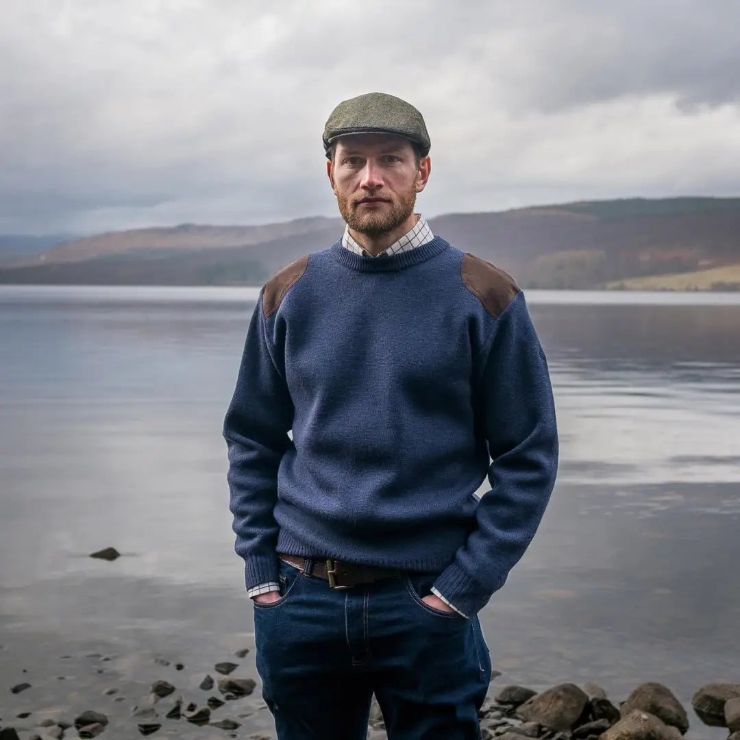 Man by the lake wearing a Melrose Hunting Pullover and flat cap for outdoor style