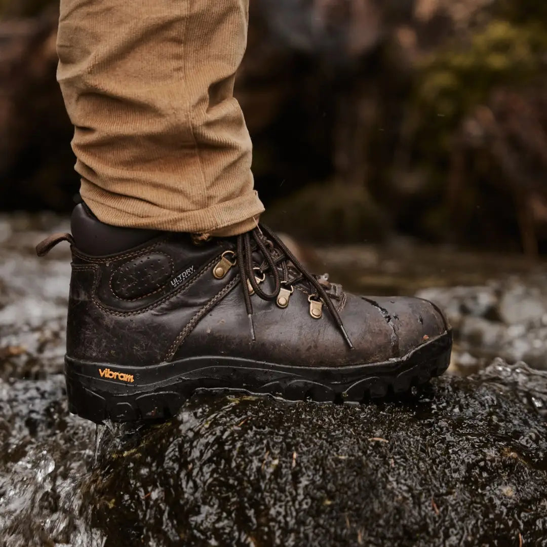 Rugged brown Fife Munro hiking boot with Vibram sole on a rock for outdoor adventures