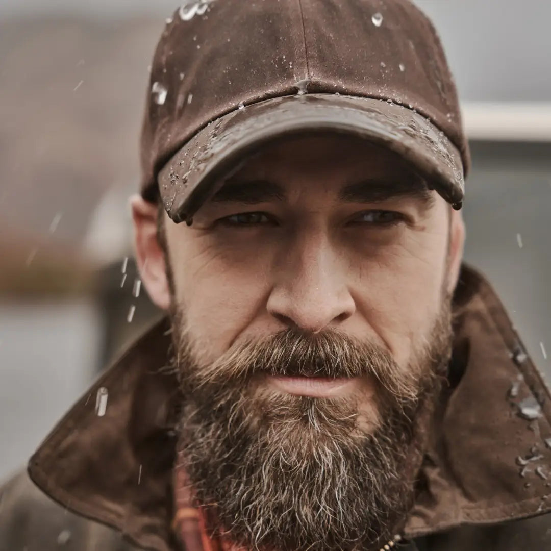 Bearded man in brown cap and jacket enjoying snowy weather with Fife Struther Waterproof Cap