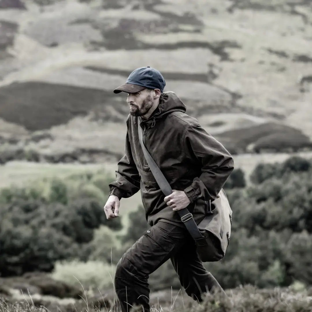 Man in Hoggs Of Fife Struther Waterproof Field Smock exploring rugged terrain