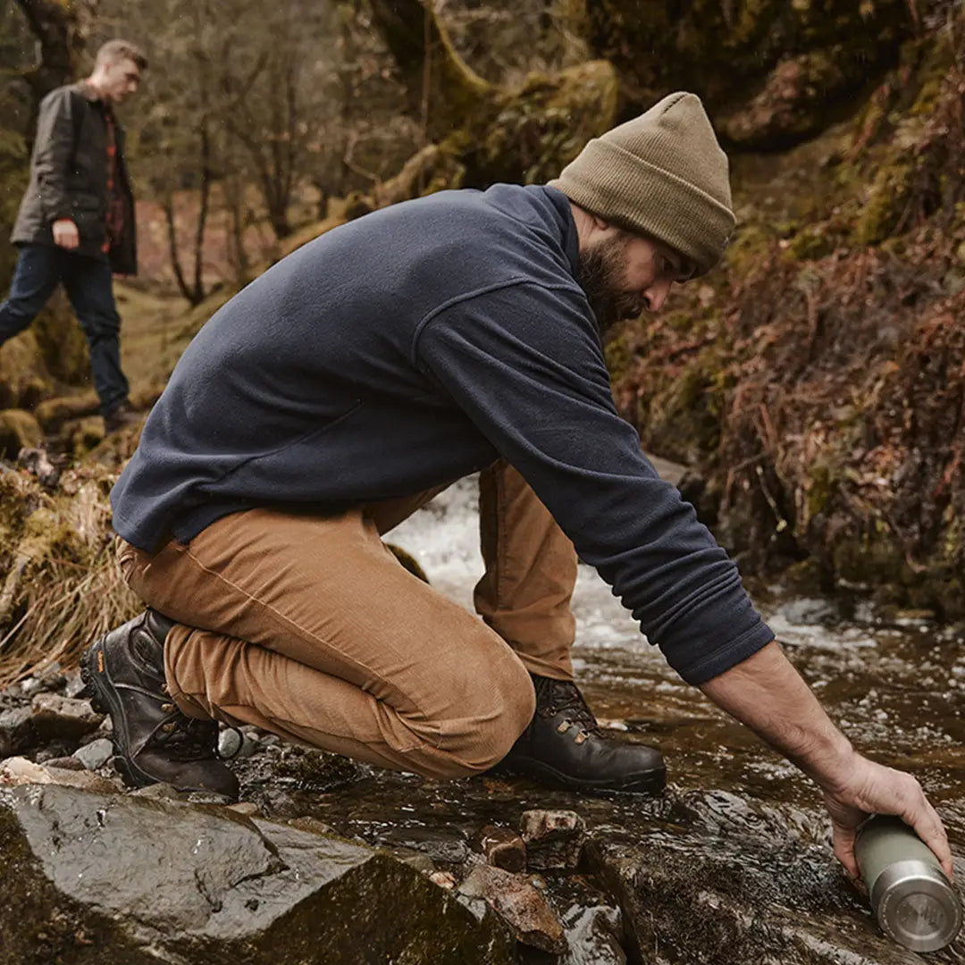 Person by a stream wearing a Thinsulate beanie, perfect for country clothing and hunting