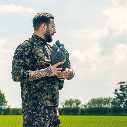 Camouflaged hunter in Jack Pyke Armour Long Sleeved Top with decoys ready for action