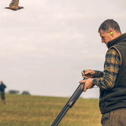 Man with a shotgun in a field, showcasing Jack Pyke Flannel Shirt style