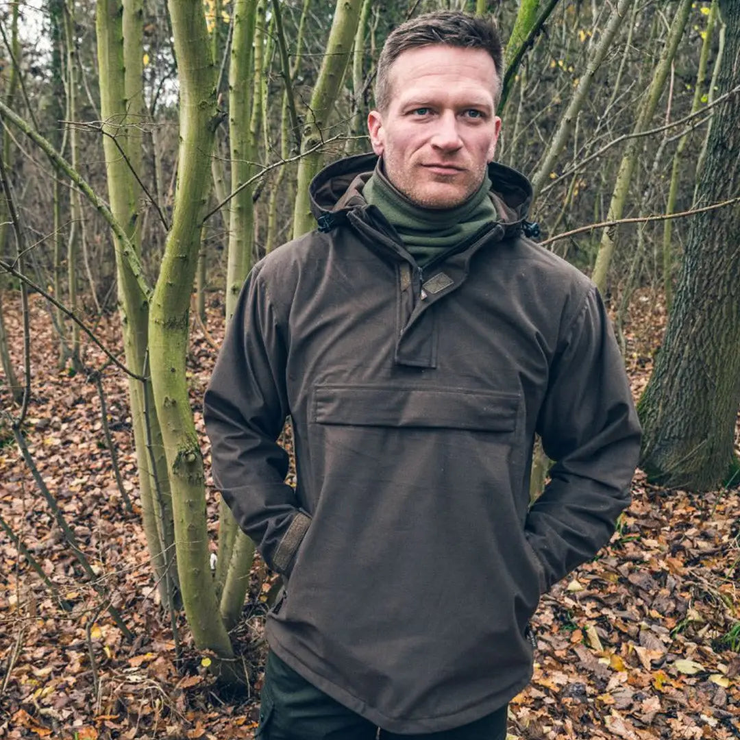 Man in a dark hooded jacket in woods showcasing the Jack Pyke Galbraith Smock