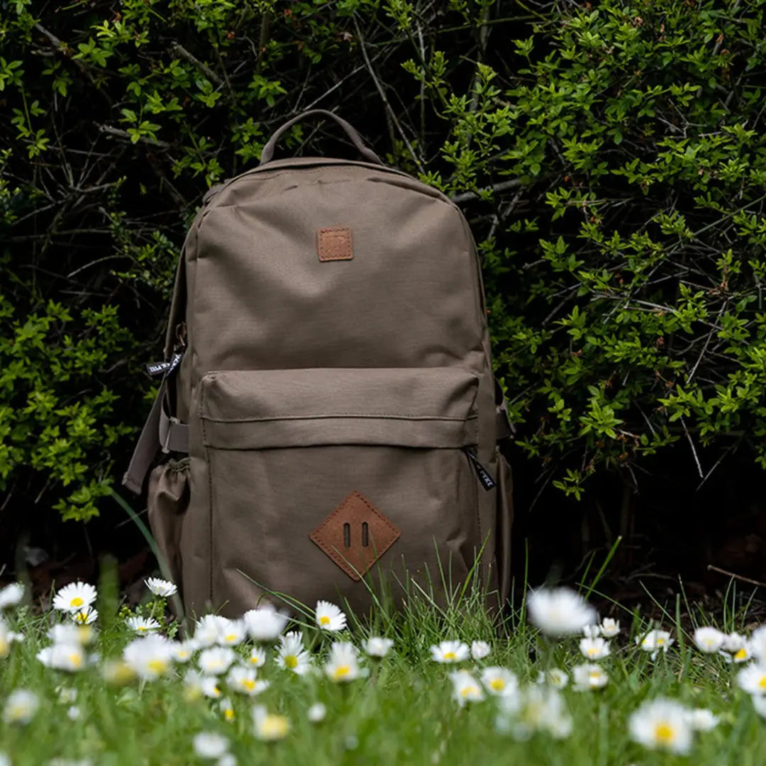 Khaki Pyke Harrier Rucksack with leather accents on grass, perfect for outdoor adventures