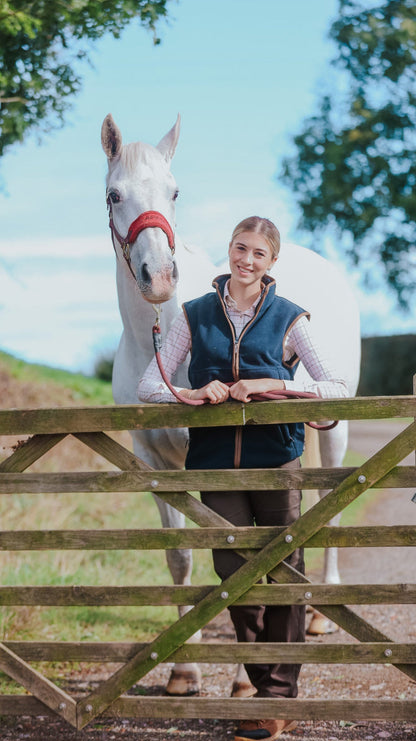 Smiling woman wearing Jack Pyke Ladies Countryman Fleece Gilet with white horse