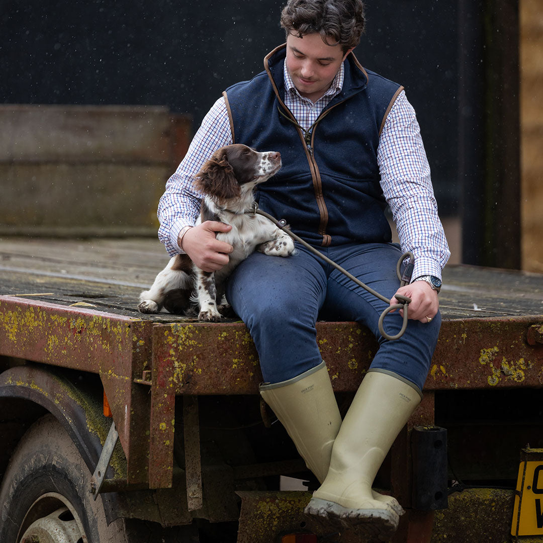 Man sitting with dog in Jack Pyke Melange Fleece Gilet Navy, showcasing comfort and style