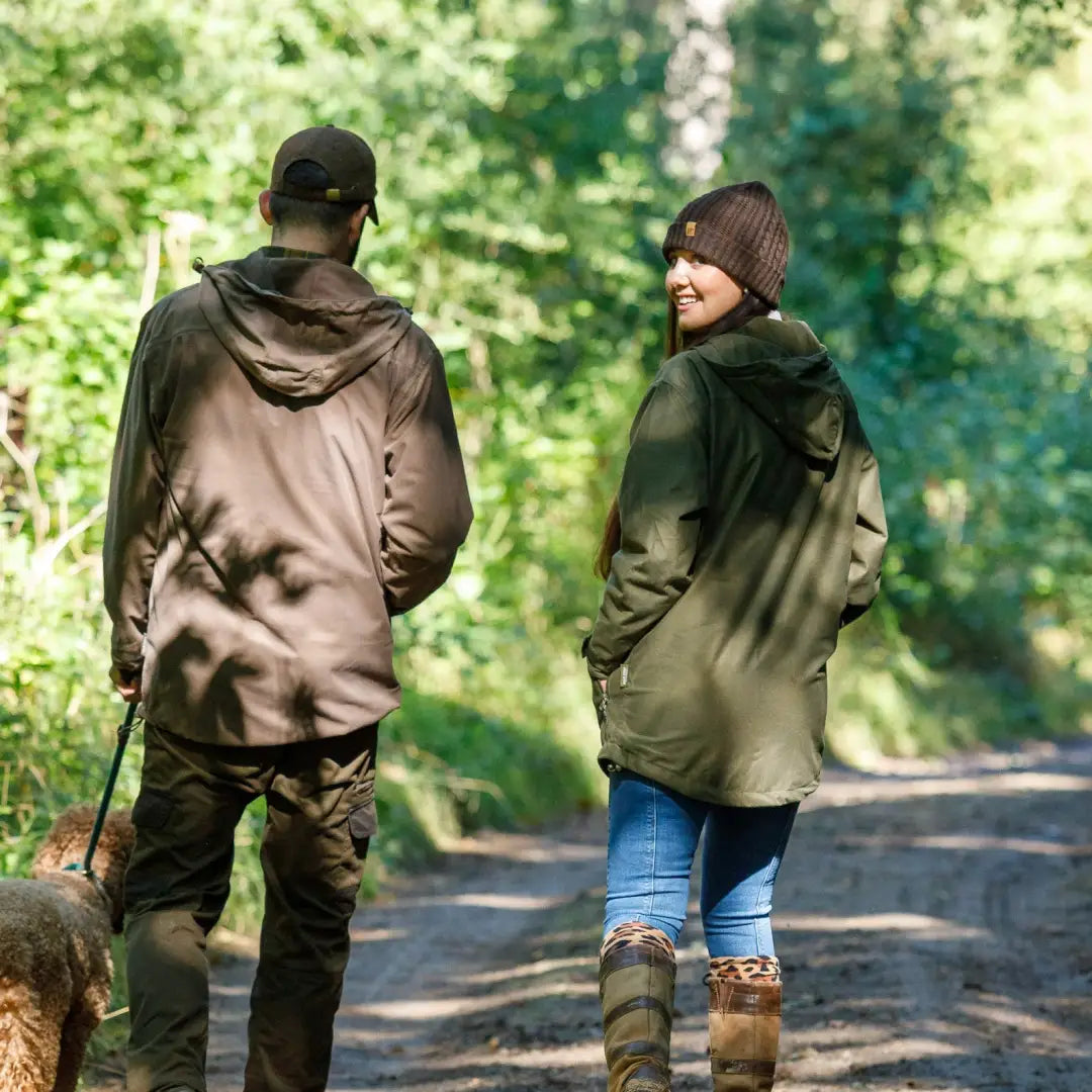 Two people walk a dog on a forest path, wearing Jack Pyke Merino Wool Beanie