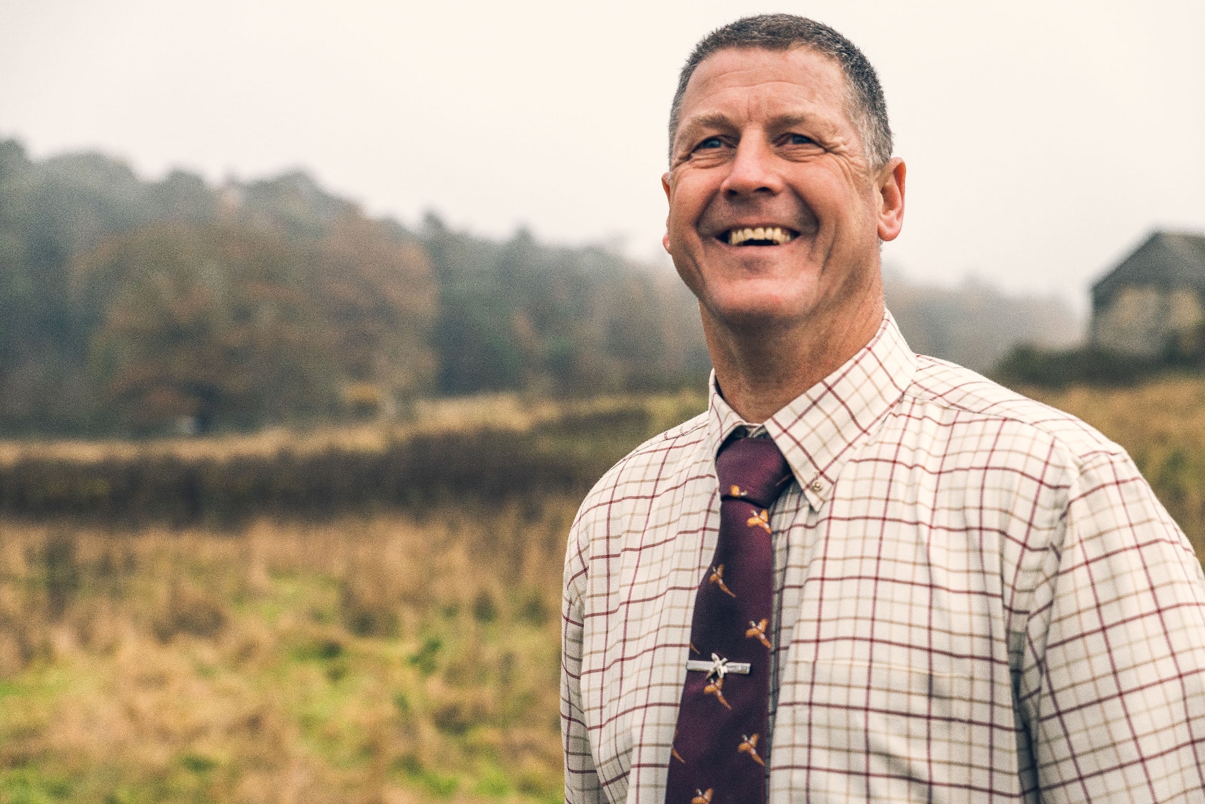 Smiling man in patterned shirt and tie wearing a Jack Pyke pheasant tie clip