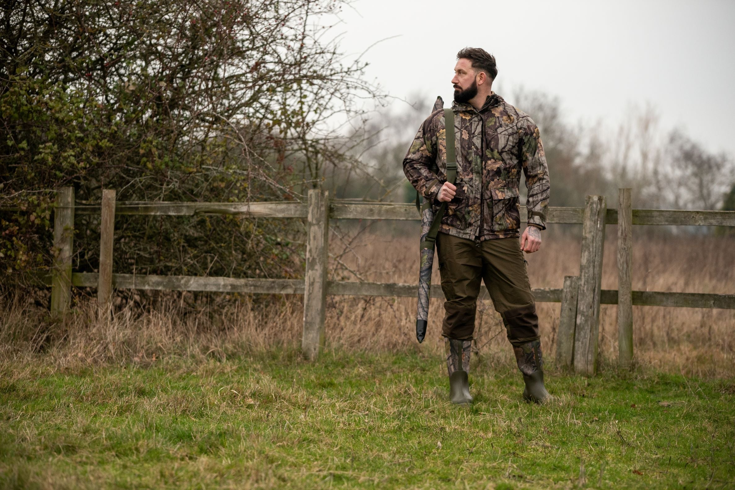 Hunter with rifle wearing Jack Pyke Rannock Waterproof Hunting Jacket in the outdoors