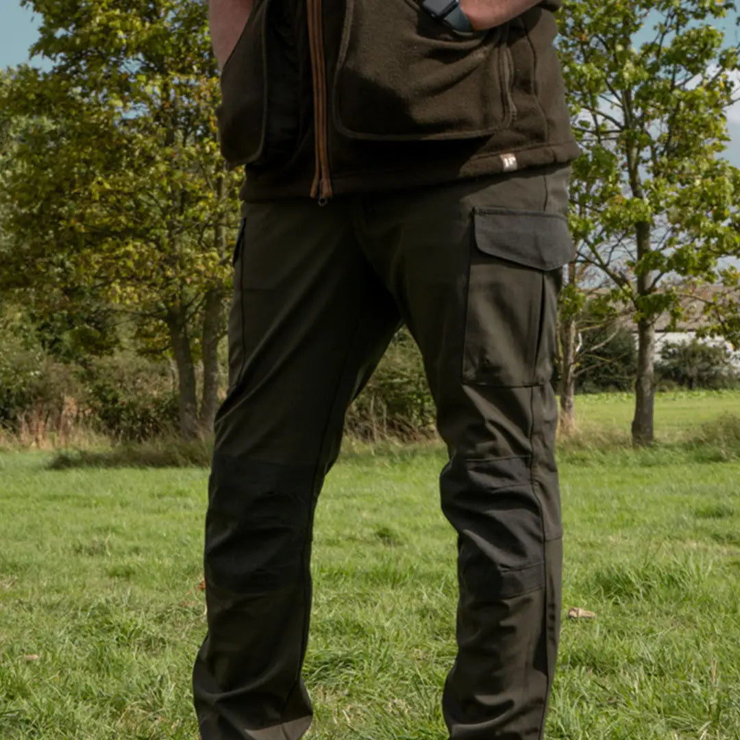 Dark green Jack Pyke Softshell Trousers with multiple pockets worn outdoors