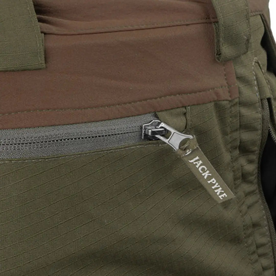 Zipper pull on Jack Pyke Technical Hybrid Trousers in green and brown fabric