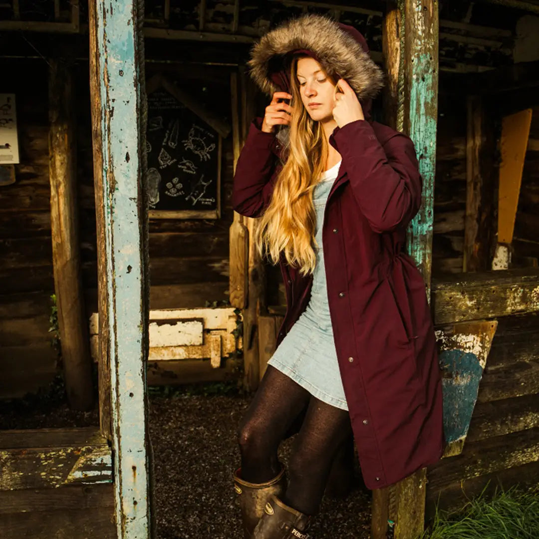 Woman in a burgundy Keela Womens Crofter Parka, perfect for country clothing and outdoors