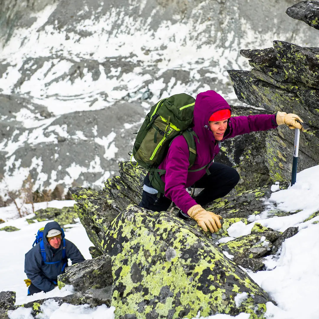 Mountain climber in a snow-covered rocky slope wearing a Keela Womens Prosport Jacket