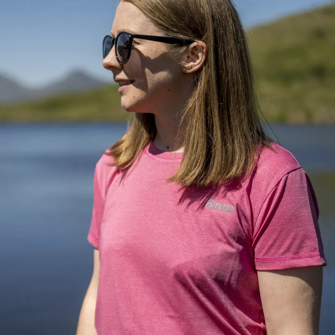 Woman in a bright pink t-shirt with sunglasses, featuring Polygiene ViralOff™ treatment