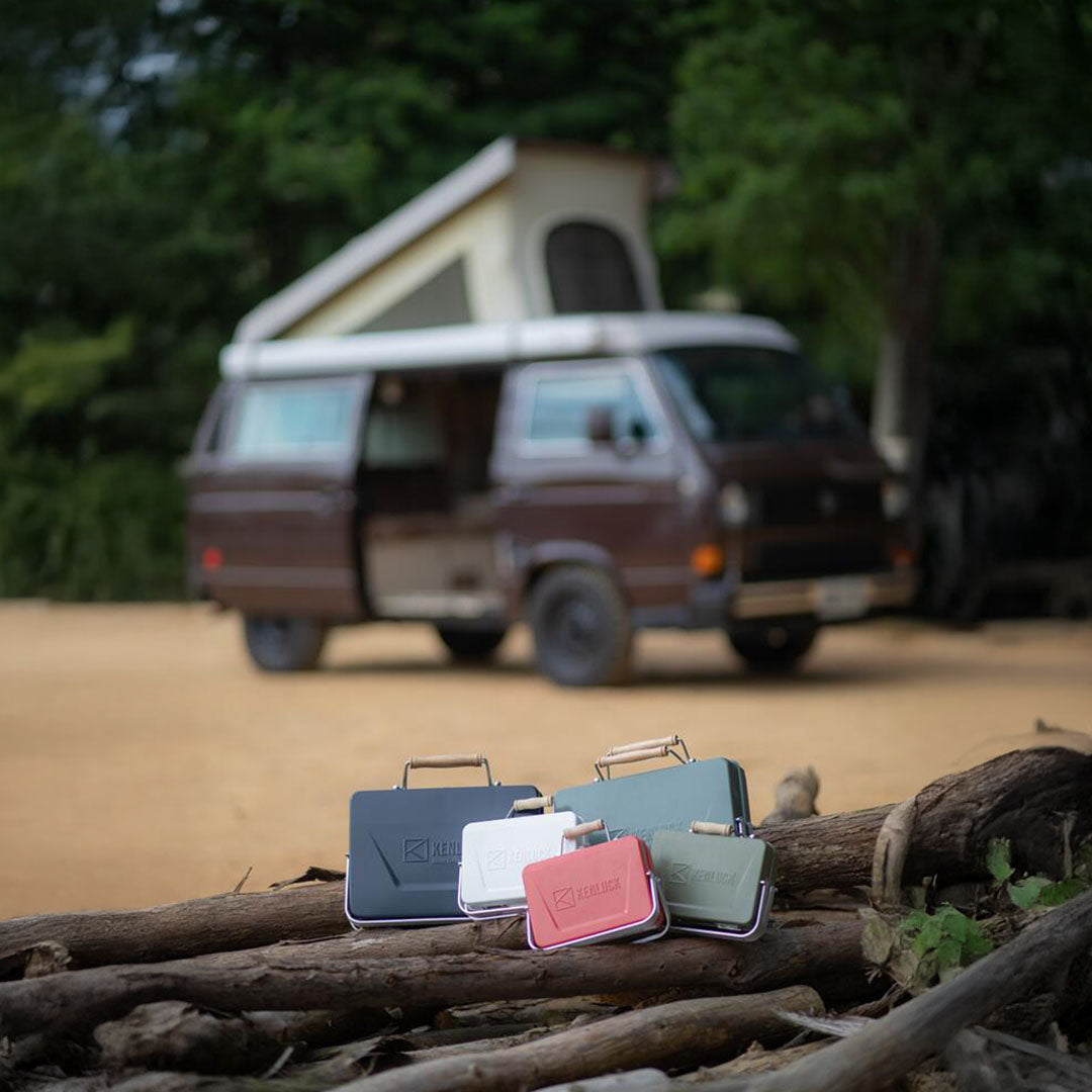 Colorful portable coolers next to the Kenluck Mini Grill for outdoor fun