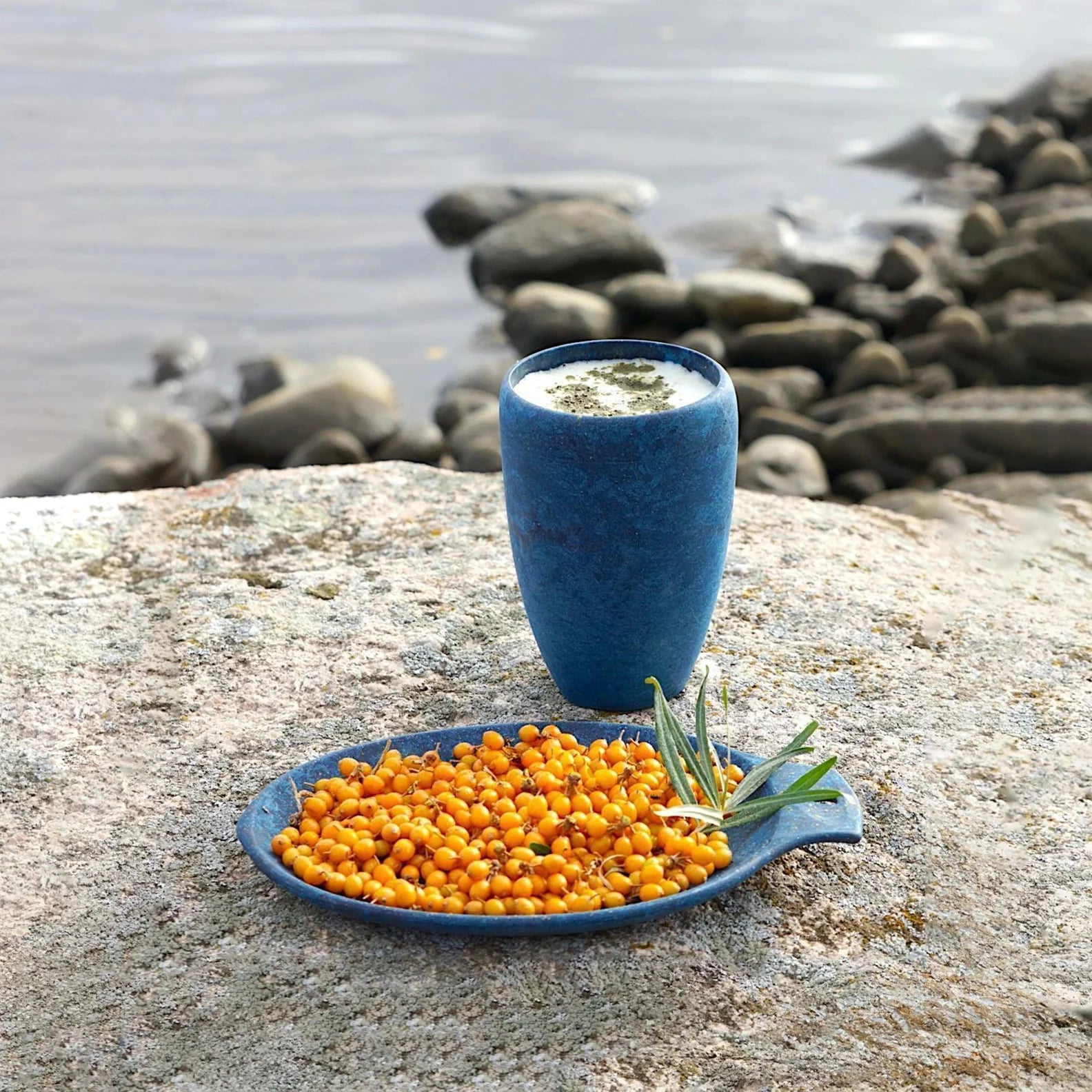 Blue Kupilka Cup Coffee Go with plate and sea buckthorn berries, perfect for outdoor vibes