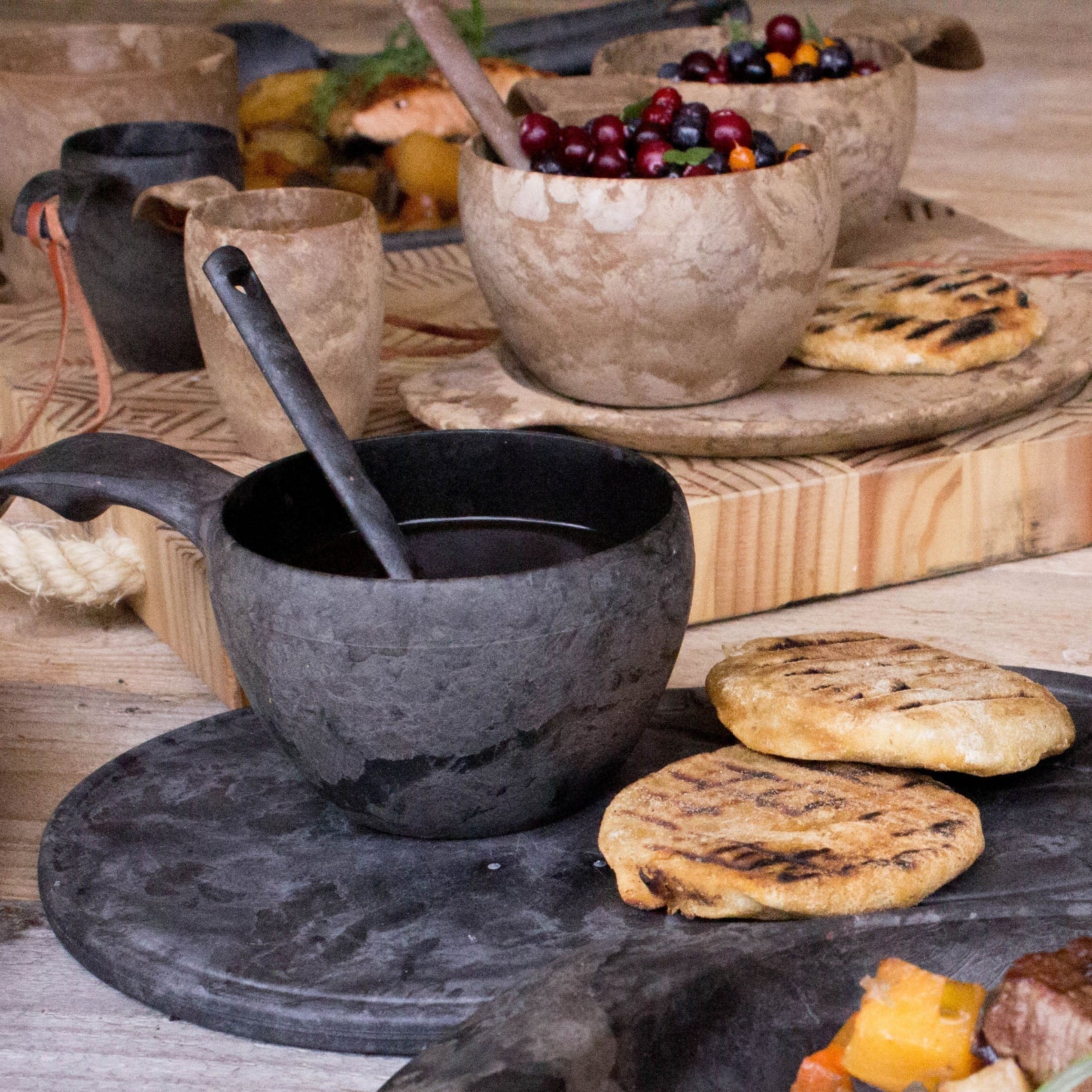 Rustic black handled bowl on Kupilka Kaarna Small Service Tray for stylish serving