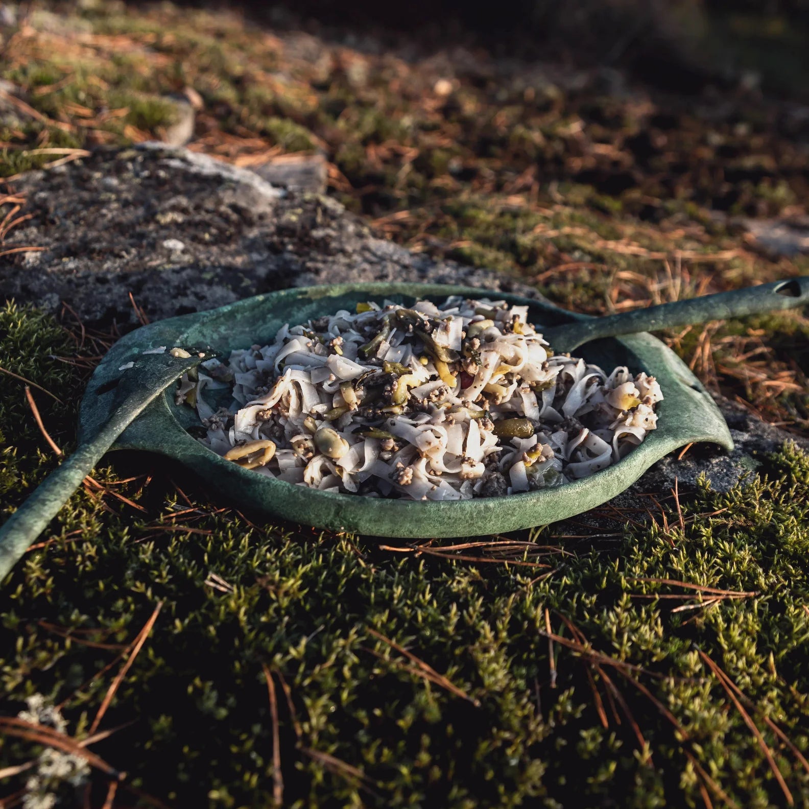 Green leaf-shaped Kupilka Plate filled with delicious food, perfect for outdoor adventures