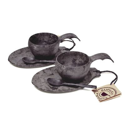 Two dark gray cup and saucer sets with spoons in the Kupilka Slow Down Gift Set