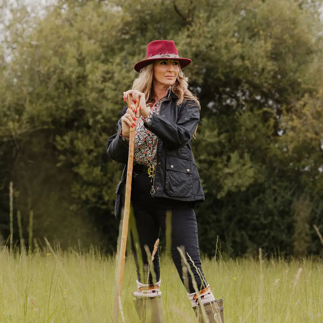 Woman in red hat and jacket enjoying the outdoors in a ladies antique wax jacket