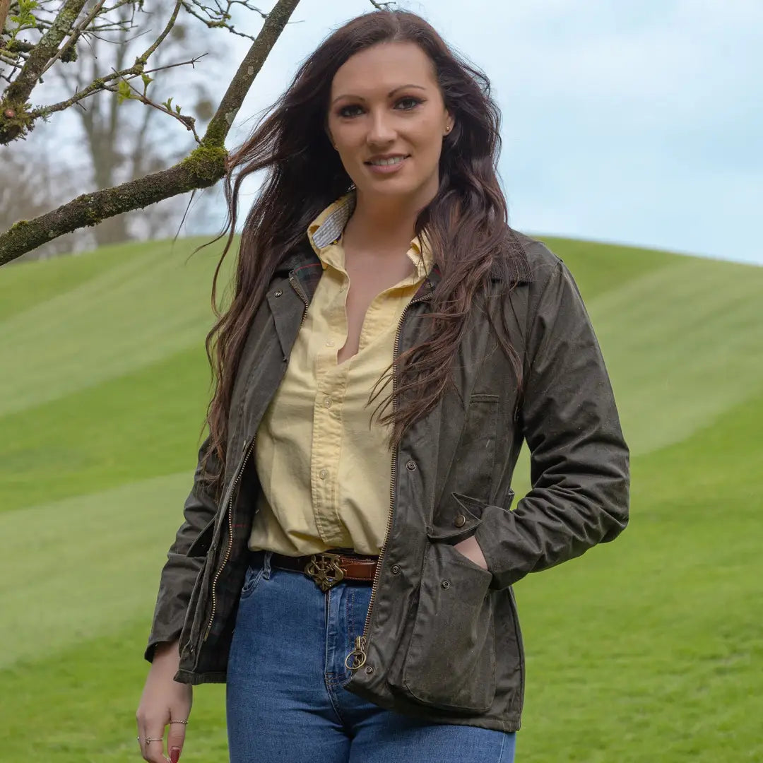 Woman in a green Antique Wax Jacket and yellow shirt enjoying the outdoors