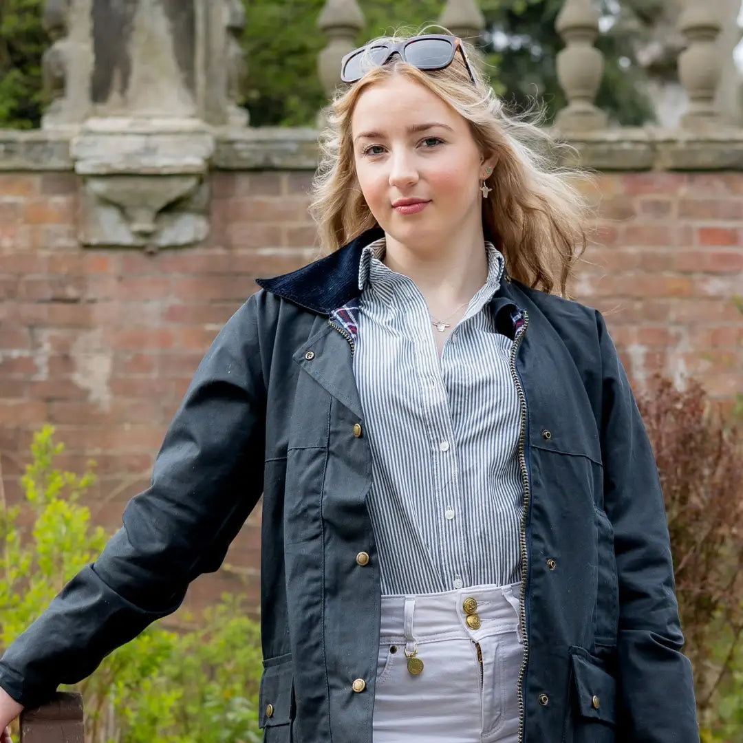 Young woman in a navy padded wax jacket with sunglasses, showcasing style and comfort