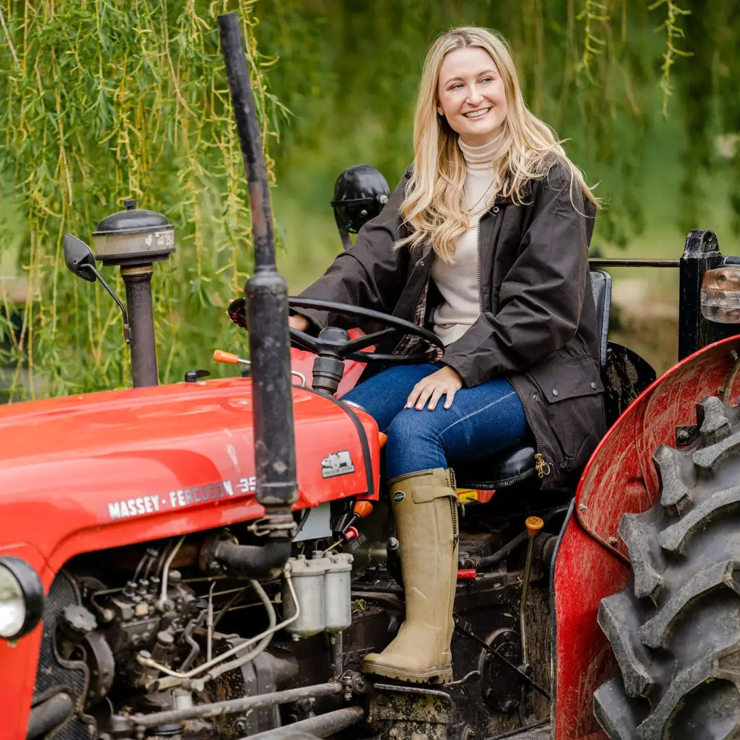 Red tractor with person in Ladies Padded Wax Jacket ready for outdoor adventures