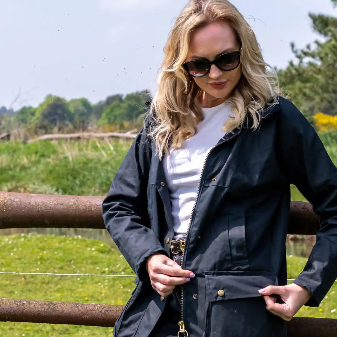 Woman in sunglasses rocking a Ladies Traditional Wax Jacket in a beautiful rural setting