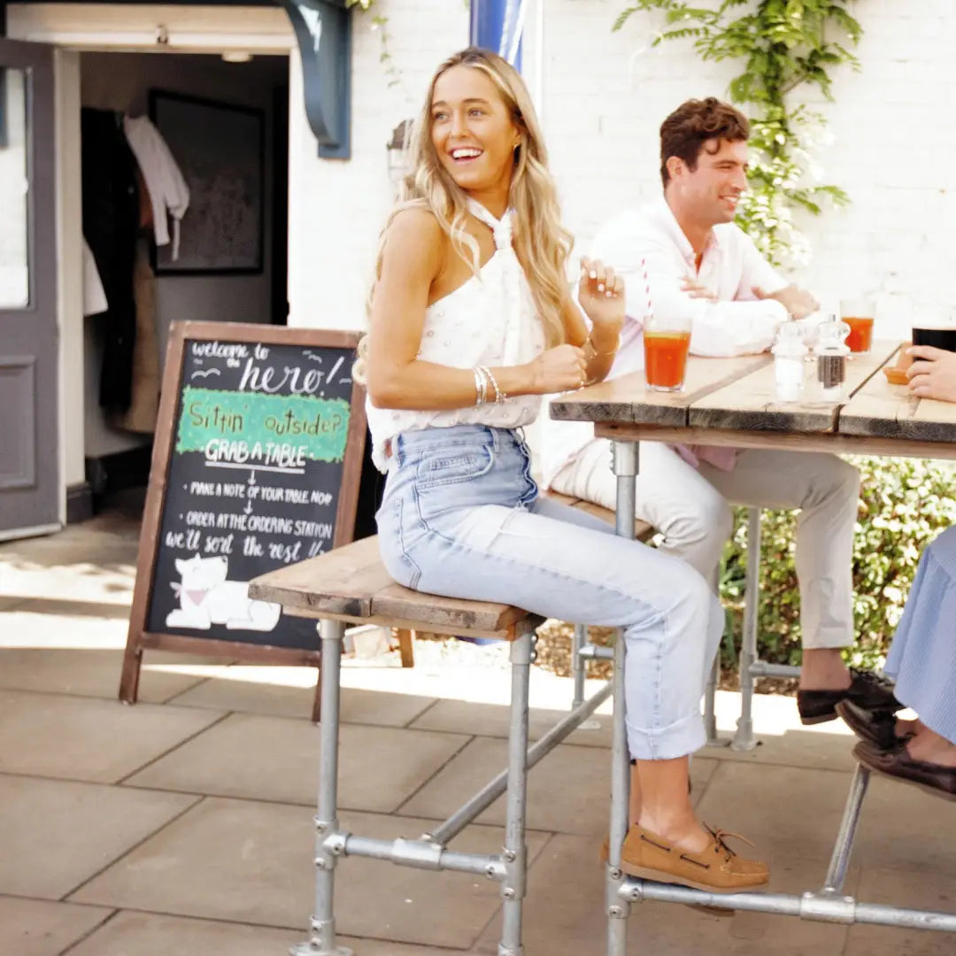 Smiling blonde woman enjoying her fantastic Galion Nubuck deck shoes at a cafe