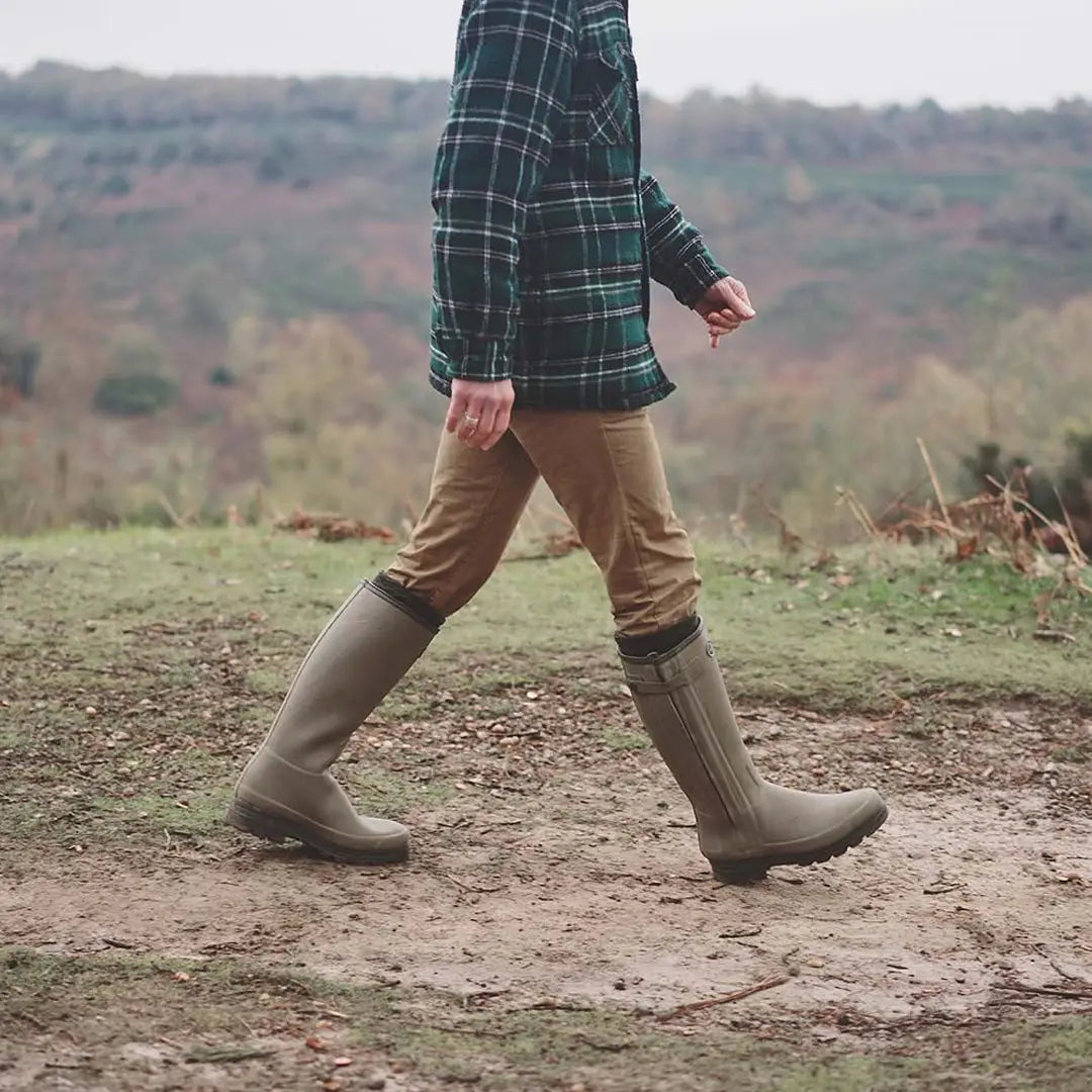 Person in plaid jacket and tall rubber boots on dirt path, showcasing Premium Neoprene Lined footwear